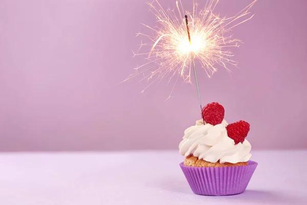 Смачний день народження кекс з іскристом на кольоровому столі — стокове фото