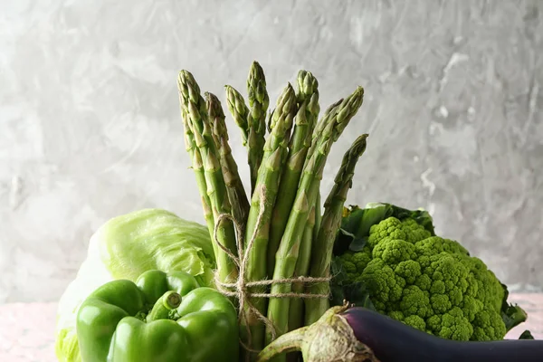 Olika färska grönsaker på grå bakgrund — Stockfoto