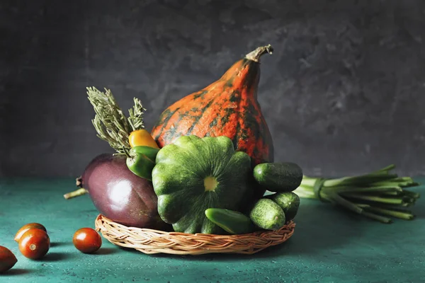 Плетеный поднос с различными свежими овощами на цветном столе — стоковое фото