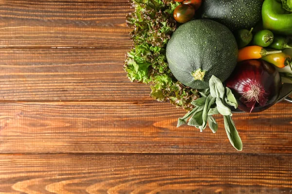 Колендр с различными свежими овощами на деревянном столе — стоковое фото