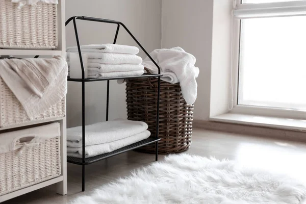 Wicker baskets with dirty laundry and folded clean towels on shelves — Stock Photo, Image