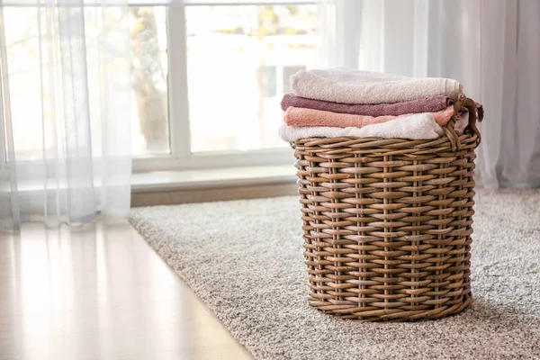 Weidenkorb mit gefalteten sauberen Handtüchern auf dem Boden — Stockfoto