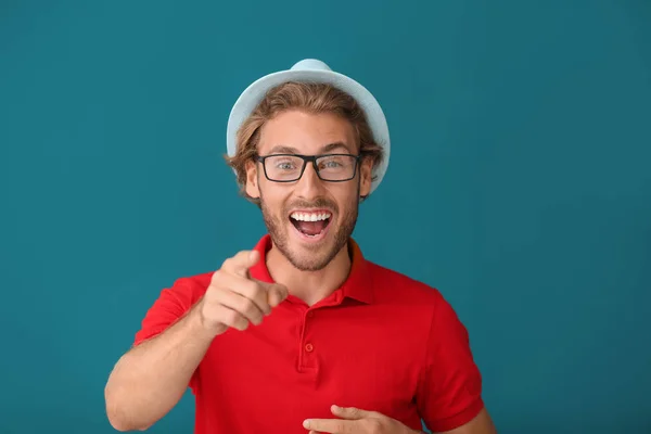 Handsome happy man pointing at viewer on color background — Stock Photo, Image