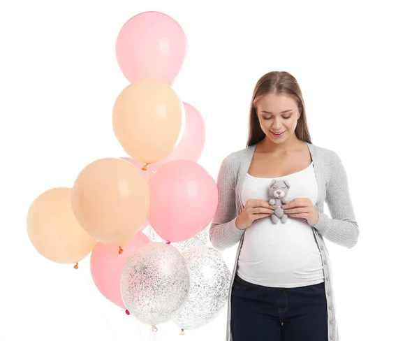 Schöne schwangere Frau mit Spielzeug und Luftballons auf weißem Hintergrund — Stockfoto