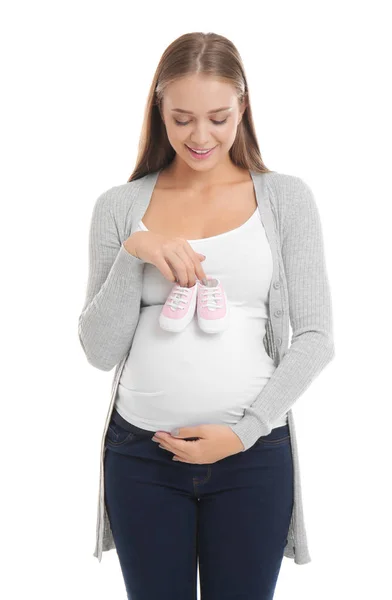 Schöne schwangere Frau mit Baby-Booties auf weißem Hintergrund — Stockfoto