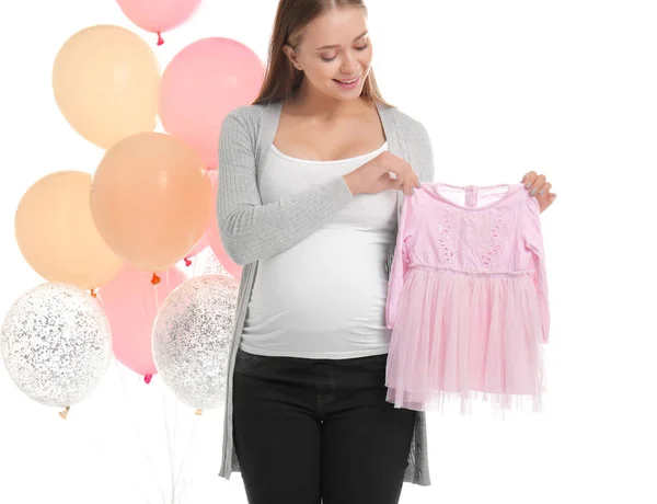 Femeie gravidă frumoasă cu rochie pentru copii și baloane de aer pe fundal alb — Fotografie, imagine de stoc