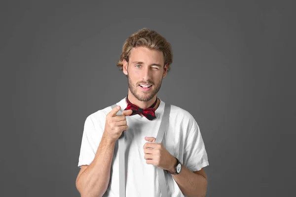 Portrait of handsome man pointing at viewer on grey background — Stock Photo, Image