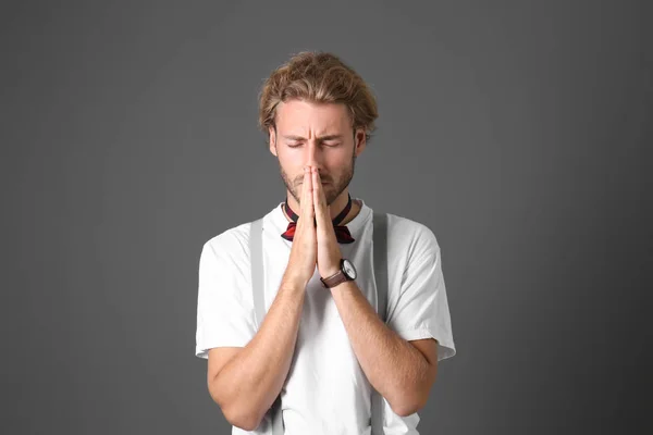 Portrait of handsome praying man on grey background — Stock Photo, Image