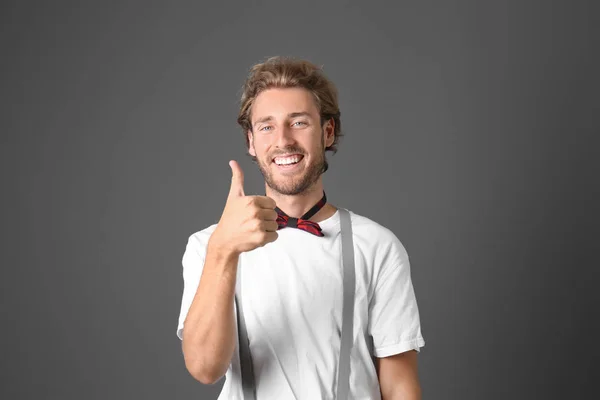Portrait of handsome man showing thumb-up on grey background — Stock Photo, Image