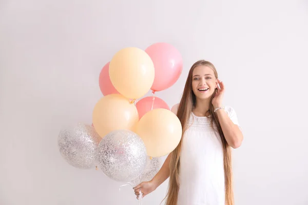 Schöne schwangere Frau mit Luftballons auf weißem Hintergrund — Stockfoto