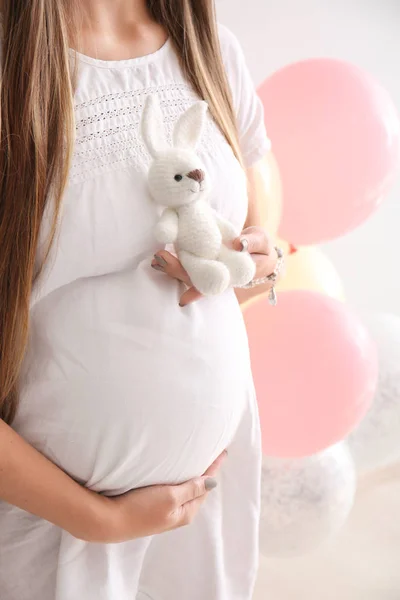 Belle femme enceinte avec jouet sur fond blanc — Photo