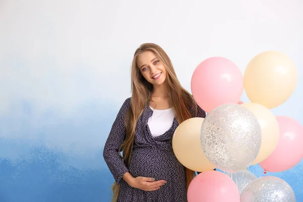 Femeie gravidă frumoasă cu baloane de aer pe fundal de culoare — Fotografie, imagine de stoc