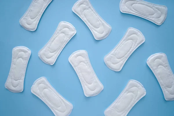 Almohadillas menstruales sobre fondo de color, vista superior — Foto de Stock