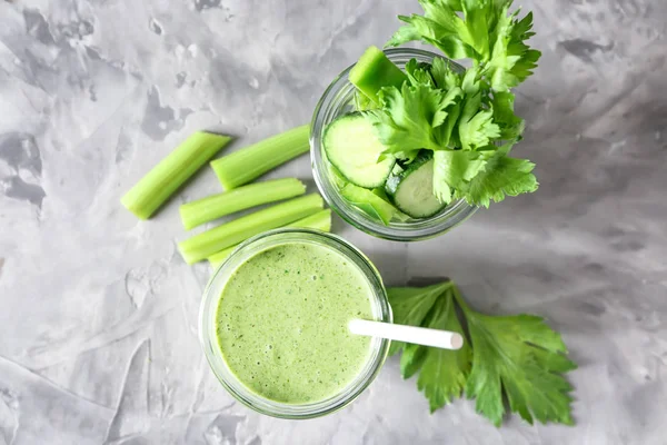 Frascos com smoothie verde saboroso e legumes cortados na mesa cinza — Fotografia de Stock