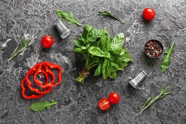 Baharatlar ve sebzeler gri arka plan üzerinde taze aromatik bitkiler