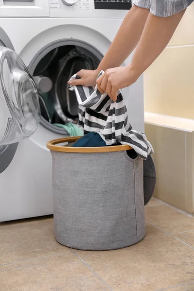 Donna che mette i vestiti in lavatrice a casa — Foto Stock