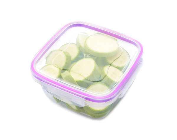 Plastic container with fresh squash for freezing on white background