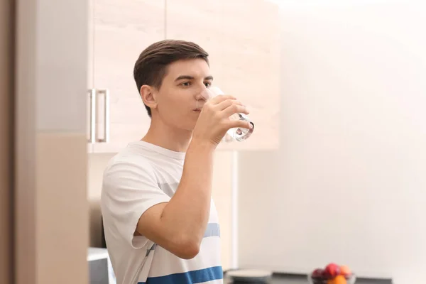 Young man drinking water at home — Stock Photo, Image
