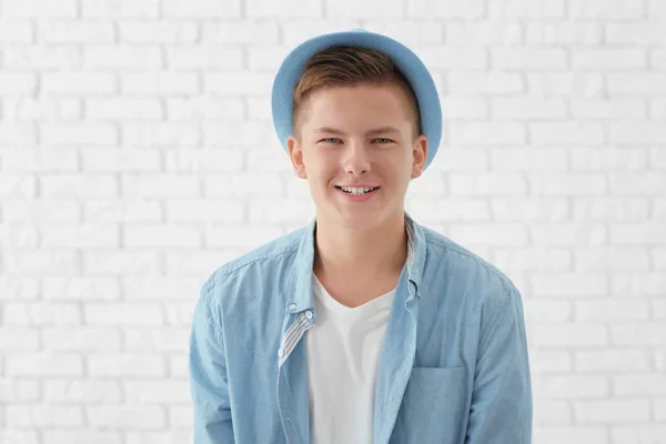 Retrato de joven guapo sonriente contra pared de ladrillo blanco —  Fotos de Stock