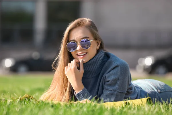 Young woman lying on green grass outdoors — Stock Photo, Image