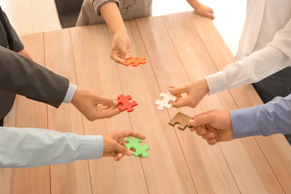 Üzleti csapat összeszerelés a puzzle a fából készült asztal — Stock Fotó
