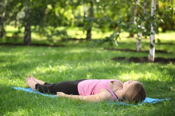 Mladá žena cvičit jógu venku — Stock fotografie