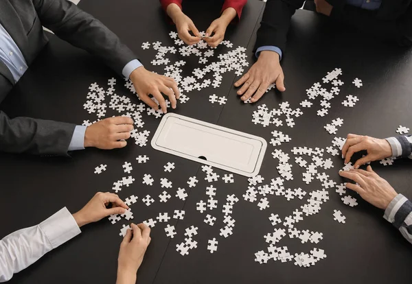 Business team di assemblaggio puzzle sul tavolo scuro — Foto Stock