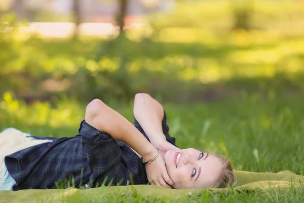 Belle jeune femme couchée sur l'herbe verte à l'extérieur — Photo