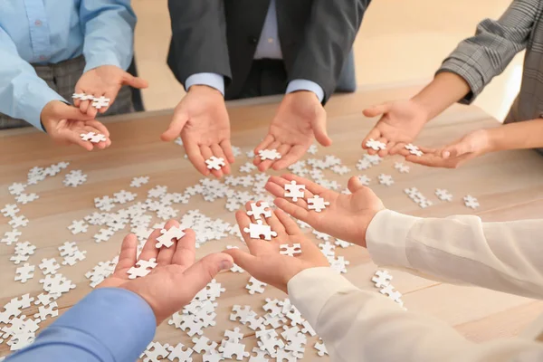 Üzleti csapat összeszerelés a puzzle a fából készült asztal — Stock Fotó