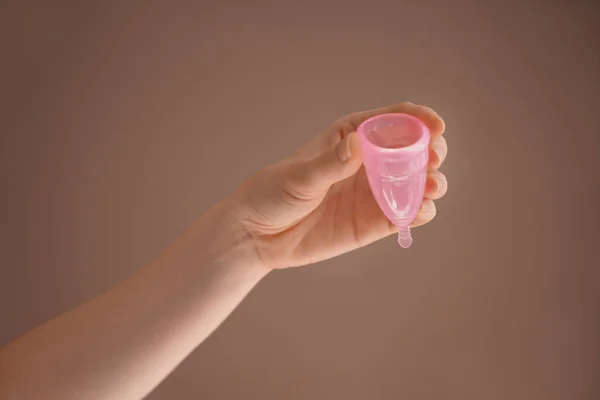Mujer sosteniendo copa menstrual sobre fondo de color —  Fotos de Stock