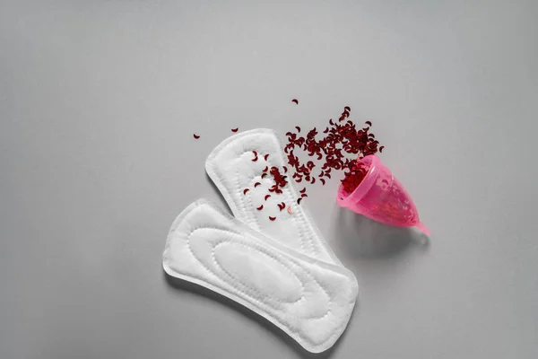 Menstruele pads met kop en rode confetti op grijze achtergrond — Stockfoto