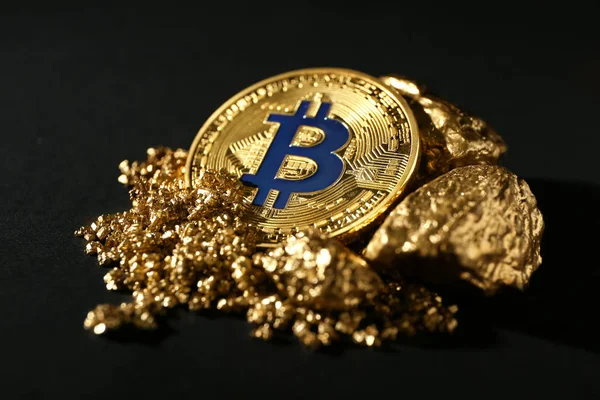 Bitcoin y pepitas de oro sobre fondo negro — Foto de Stock