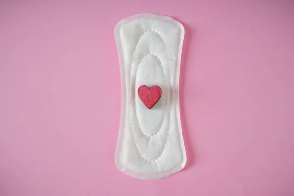 Menstrual pad with red heart on color background — Stock Photo, Image