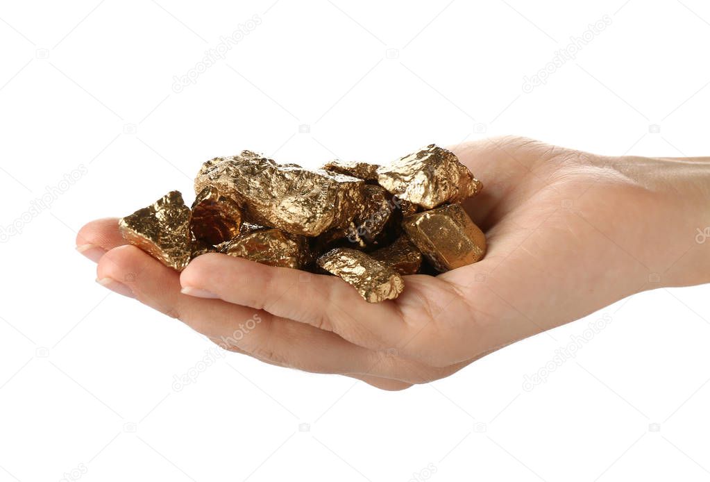 Female hand with gold nuggets on white background