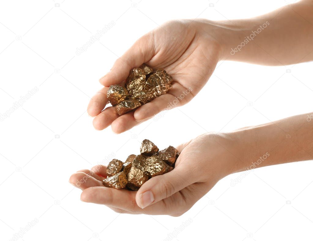 Female hands with gold nuggets on white background