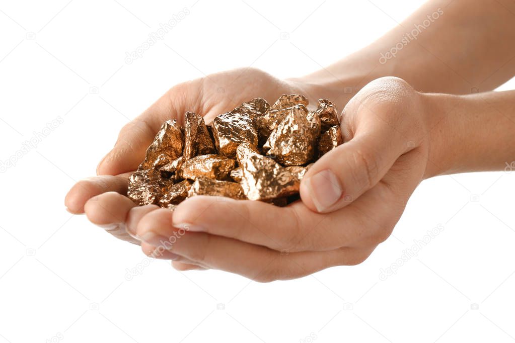 Female hands with gold nuggets on white background