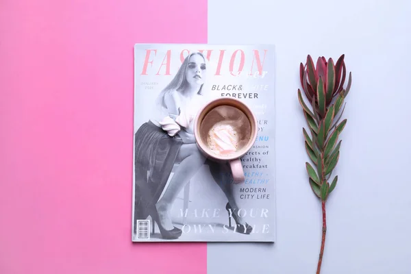 Vacker tropisk blomma med kopp kaffe och tidning på färg bakgrunden — Stockfoto