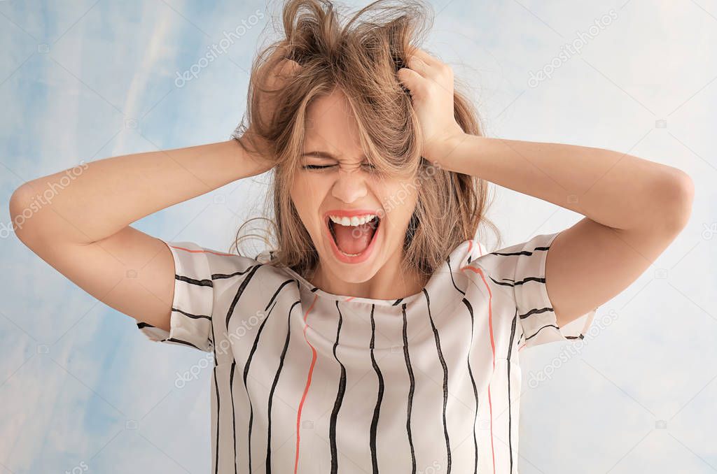 Beautiful stressed woman on color background