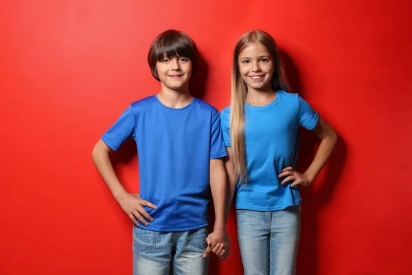 Menino e menina em camisetas no fundo de cor — Fotografia de Stock