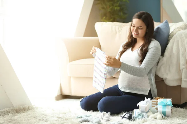 Mulher grávida bonita com presentes de chá de bebê em casa — Fotografia de Stock