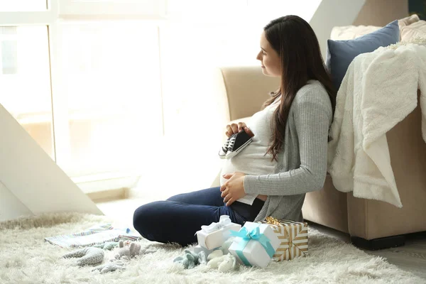 Beautiful pregnant woman with baby shower gifts at home — Stock Photo, Image