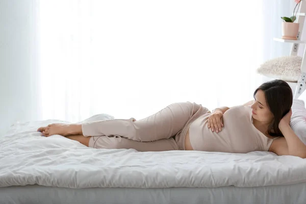 Beautiful pregnant woman lying on bed — Stock Photo, Image