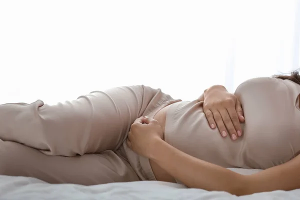 Красивая беременная женщина лежит на кровати — стоковое фото