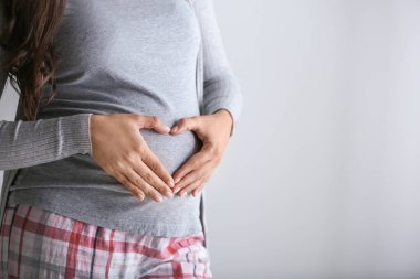 Gri arka plan, closeup üzerinde güzel hamile kadın