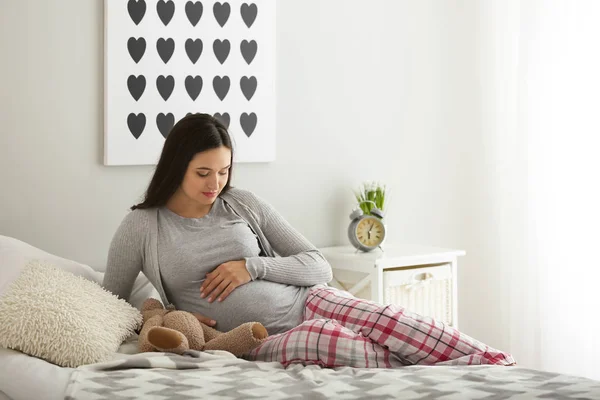 Hermosa mujer embarazada descansando en el dormitorio —  Fotos de Stock