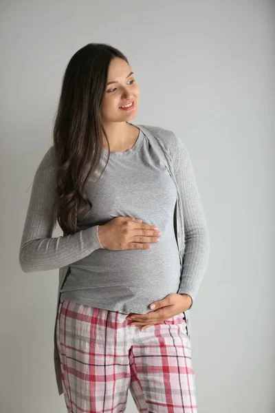 Mulher grávida bonita no fundo cinza — Fotografia de Stock