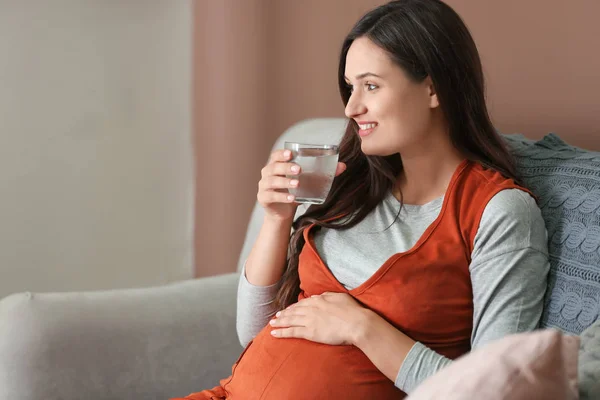 Beautiful pregnant woman drinking water at home — Stock Photo, Image