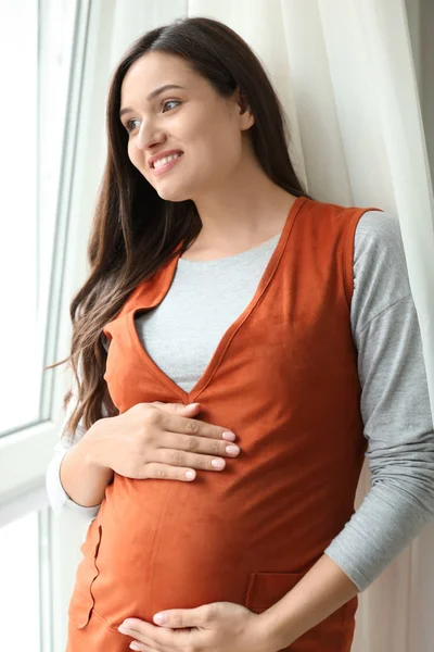 Hermosa mujer embarazada cerca de ventana —  Fotos de Stock