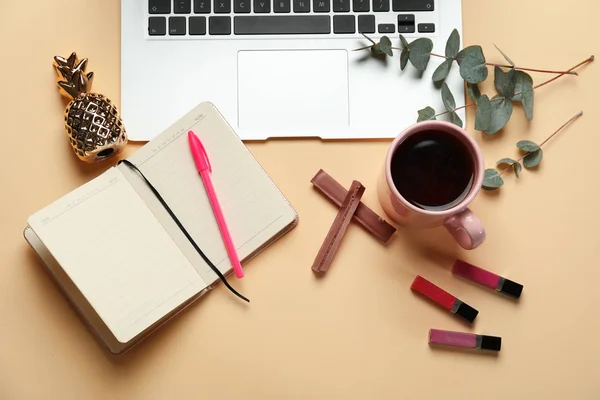 Laptop met kopje koffie-, laptop- en cosmetica op kleur achtergrond — Stockfoto