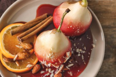 Lezzetli haşlanmış armut portakal dilimleri ve badem plaka üzerinde kırmızı şarap